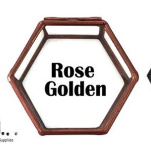 May include: Three hexagonal glass boxes with lids. The boxes are in gold, rose gold, and black.