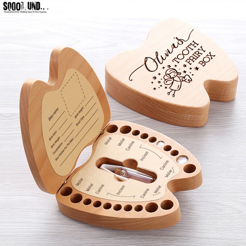 Puede incluir: Caja de dientes de hada de madera con forma de diente con un peque&ntilde;o caj&oacute;n para guardar los dientes de beb&eacute;. La caja est&aacute; grabada con el texto "Olivia's Tooth Fairy Box" y una peque&ntilde;a ilustraci&oacute;n de un hada.