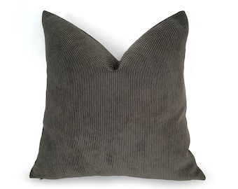May include: A dark green corduroy pillow with a textured surface.