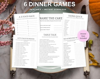 May include: Six printable dinner games with titles like "A-Z Food Race", "Name the Cake", "Table Talk", "Think Quick", and "Find Someone Who". The games are printed on white paper with black text and are laid out on a brown wooden table with a plate and a pumpkin.