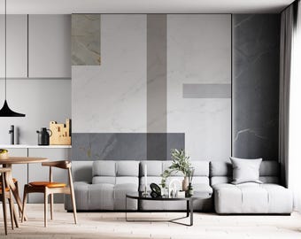 Puede incluir: Un salón moderno con un sofá seccional gris, una mesa de café negra y una pared con patrón geométrico. La pared está compuesta por diferentes tonos de gris y blanco, creando un aspecto moderno y elegante.