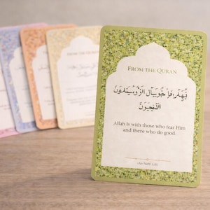 Puede incluir: Un juego de tarjetas coloridas con texto islámico. La tarjeta frontal es verde con el texto «FROM THE QURAN» y escritura árabe. También está presente el texto «Allah está con los que le temen y los que hacen el bien». Otras tarjetas son rosas, azules, naranjas y amarillas.