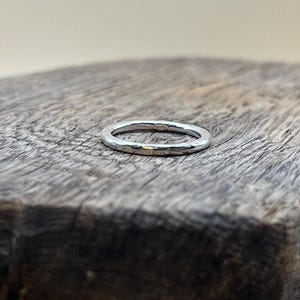 May include: A silver hammered ring with a smooth, polished finish.
