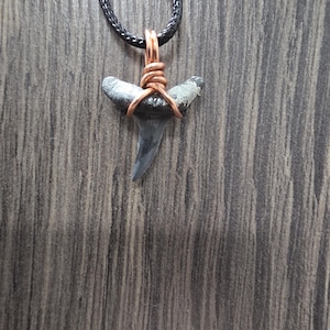 May include: A set of three ceramic mugs with a speckled, matte finish. The mugs are in shades of cream, light gray, and dark gray. Each mug has a simple, minimalist design, perfect for coffee or tea.