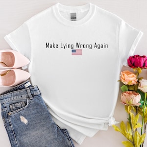 May include: White t-shirt with the text "Make Lying Wrong Again" and a small American flag graphic.