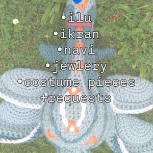 Op de afbeelding: Een handgemaakt, blauw en wit gehaakt wezen met oranje accenten, liggend op gras. De tekst "Pandoran commissions" staat bovenaan, met een lijst met termen: ilu, ikran, navi, jewlery, costume pieces en requests.