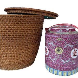 May include: A brown woven wicker basket with a matching lid and a cylindrical ceramic teapot featuring a magenta background with intricate floral patterns, a yellow sunflower motif, white circular medallions with black text, and a red handle.