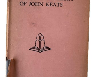 May include: A vintage book titled "The Complete Poetry of John Keats" with a faded pink cover. The cover features black text and a stylized illustration of an open book with a fountain design. The book shows signs of wear.