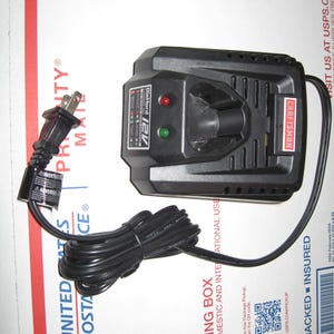 May include: Black Craftsman 12V Drill/Driver charger with a red and green indicator light. The charger has a black power cord with a standard US plug.
