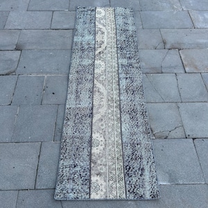 Peut inclure: Un tapis de couloir vintage bleu et blanc avec un motif géométrique. Le tapis a un aspect délavé et est en laine.