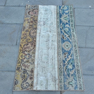 Può includere: Un tappeto vintage con tre pannelli. Il pannello sinistro è un motivo floreale giallo e marrone. Il pannello centrale è un motivo floreale bianco e crema. Il pannello destro è un motivo floreale blu e crema.