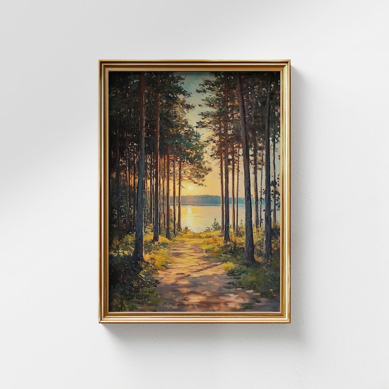 May include: Framed landscape painting showing a path through a forest of tall trees, leading to a lake at sunset. The artwork features warm tones of gold, orange, and brown, with a golden frame.