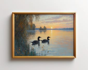 Könnte beinhalten: Ein gerahmtes Landschaftsgemälde, das zwei Eistaucher zeigt, die bei Sonnenuntergang auf einem ruhigen See schwimmen. Die Szene zeigt goldenes Licht, das sich auf dem Wasser spiegelt, dunkle Baum-Silhouetten am Ufer und einen weichen Himmel.