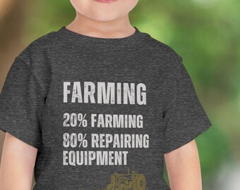 Puede incluir: Una camiseta gris oscuro jaspeada con el texto "FARMING 20% FARMING 80% REPAIRING EQUIPMENT" y un pequeño gráfico de tractor.