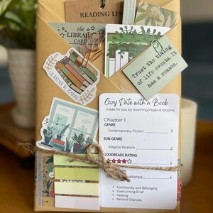 May include: A wrapped book package with decorative stickers, a library card, and a reading list. The package is tied with twine and includes a card that says "Trust the timing of life events. It has a reason."
