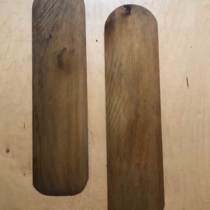 Puede incluir: Dos palas de madera con extremos redondeados, ambas son de color marr&oacute;n claro con un patr&oacute;n de veta de madera.