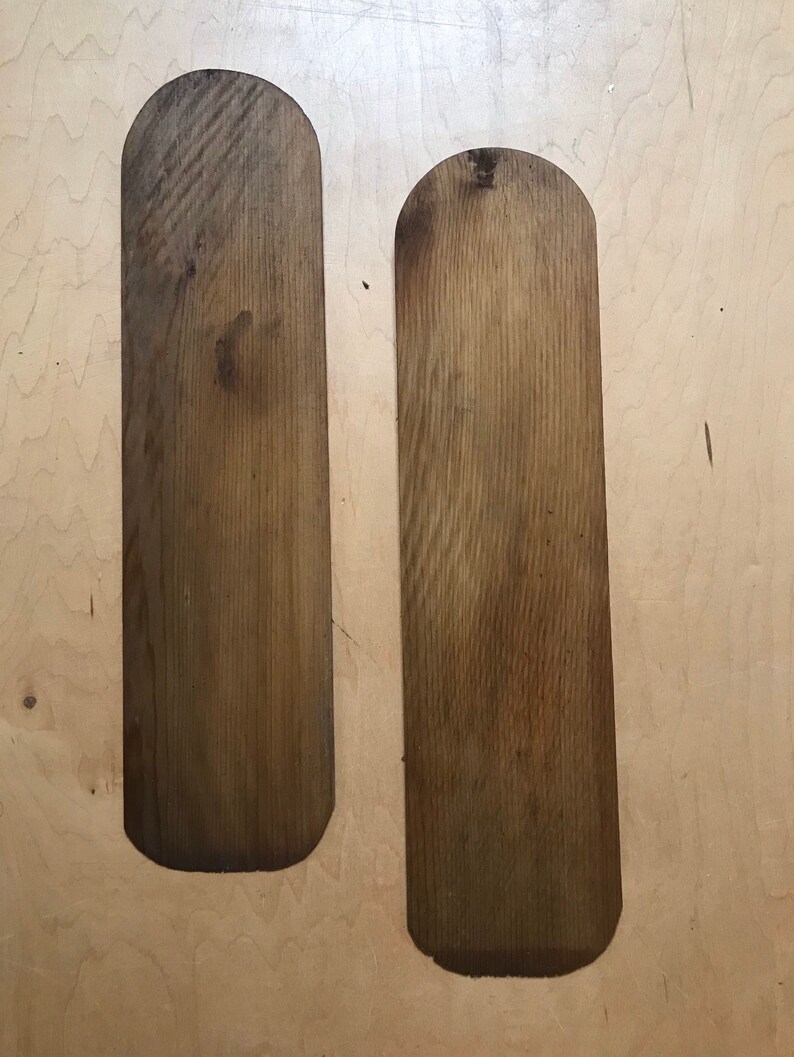 Puede incluir: Dos palas de madera con extremos redondeados, ambas son de color marr&oacute;n claro con un patr&oacute;n de veta de madera.
