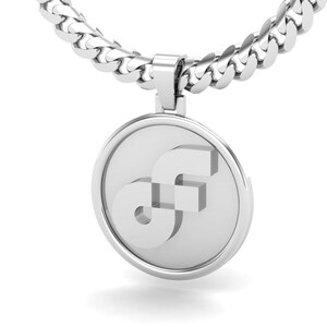 Puede incluir: Un collar con colgante plateado con un colgante circular con un diseño estilizado "SF". El colgante cuelga de una gruesa cadena de eslabones. El diseño es moderno y minimalista, adecuado para el uso diario.