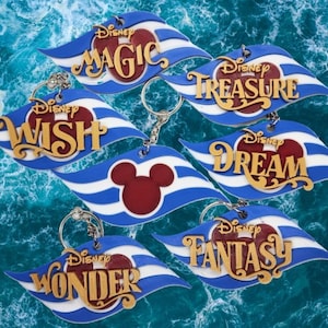 May include: Set of seven Disney Cruise Line keychains featuring the names of different ships: Magic, Wish, Dream, Fantasy, Wonder, and Treasure. Each keychain is a blue and white striped wave with a red Mickey Mouse head and gold lettering.