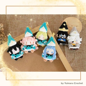 May include: Six small, handmade crochet plush dolls featuring various hair colors and pointed hats with white flower accents. The dolls have distinct facial features and colorful yarn outfits, arranged together on a wooden surface.