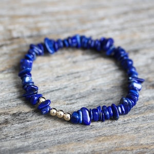 May include: A blue lapis lazuli chip bead bracelet with gold beads.