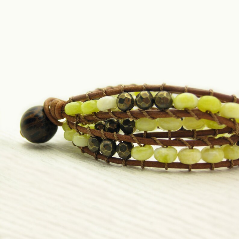 May include: A multi-strand bracelet with brown leather cord and green and brown beads.