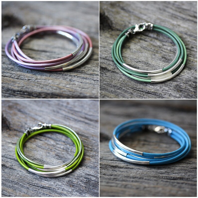 May include: Four leather wrap bracelets with silver accents. The bracelets are in the colors pink, green, light green, and blue.
