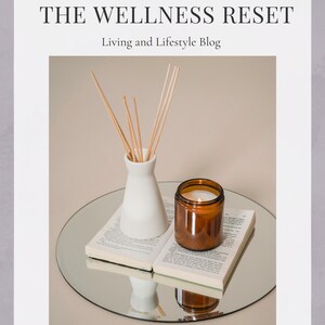 May include: A white ceramic vase with wooden sticks and a brown glass candle on a book and a round mirror. The text "THE WELLNESS RESET" and "Living and Lifestyle Blog" is on the image.