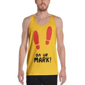 Könnte beinhalten: Senfgelbes Tanktop mit roten Fußabdrücken und dem Text "ON UR MARK!" in Schwarz. Das Tanktop ist ärmellos und hat einen runden Ausschnitt. Das Design befindet sich auf der Vorderseite.