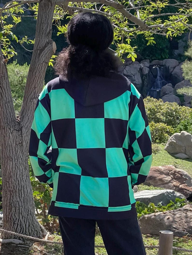 Puede incluir: Una sudadera con capucha a cuadros negros y verdes. La sudadera est&aacute; hecha de un material suave y c&oacute;modo y tiene un corte holgado.