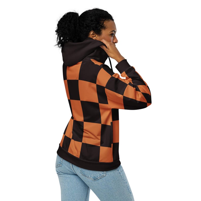 Puede incluir: Una sudadera con capucha de color negro y naranja a cuadros con capucha con cord&oacute;n. La sudadera est&aacute; hecha de un material suave y c&oacute;modo y tiene un corte holgado.