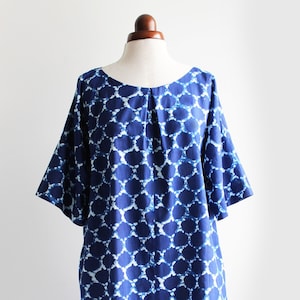 May include: A blue and white patterned dress with a round neckline and short sleeves. The dress is made of a lightweight fabric and has a relaxed fit.