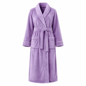 May include: A solid light purple plush bathrobe featuring a shawl collar, long sleeves with cuffs, two front patch pockets, and a matching fabric tie belt at the waist. The robe is made of a soft, fuzzy material and reaches below the knees.