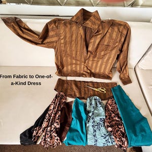 May include: A brown striped button-down shirt, a detached shirt hem, gold scissors, and various fabric swatches in black, brown, teal, and floral patterns. The text "From Fabric to One-of-a-Kind Dress" is printed on the left side of the image.