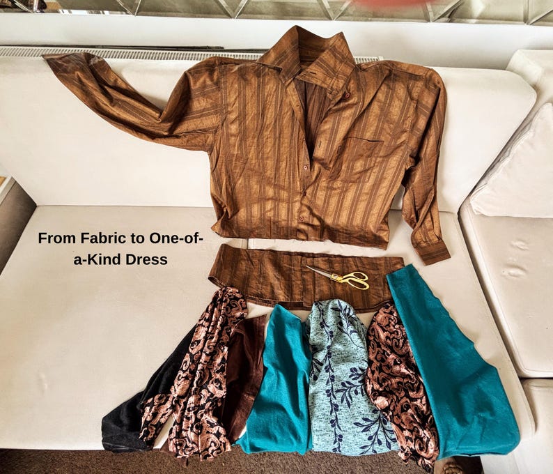 May include: A brown striped button-down shirt, a detached shirt hem, gold scissors, and various fabric swatches in black, brown, teal, and floral patterns. The text "From Fabric to One-of-a-Kind Dress" is printed on the left side of the image.