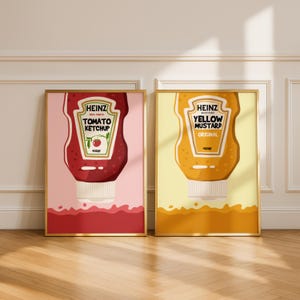 Puede incluir: Dos láminas enmarcadas con botellas de ketchup y mostaza amarilla Heinz. La lámina de ketchup muestra una botella roja sobre un fondo rosa, con el texto "Tomato Ketchup". La lámina de mostaza muestra una botella amarilla sobre un fondo amarillo.
