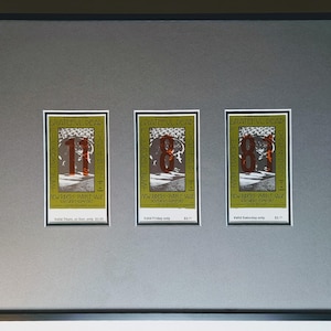 May include: Framed artwork featuring three vintage concert tickets. Each ticket has a green border with the text "Grateful Dead" and a large number. The tickets are mounted on a gray background within a black frame.