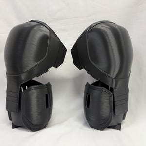 May include: Two black knee and shin protectors. The armour is made from a hard-wearing material and has a contoured design for a comfortable fit. The protectors are designed to protect the knees and shins from impact.