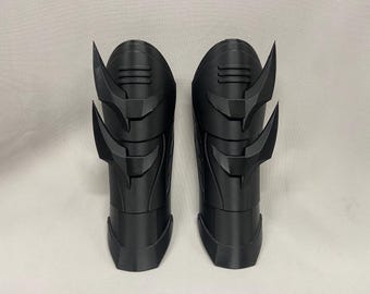 May include: A pair of black plastic forearm guards with a spiky design. The guards are made of a 3D printed material.