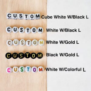 Pode incluir: Uma variedade de contas personalizadas que soletram "CUSTOM" em v&aacute;rias cores. As contas s&atilde;o brancas com letras pretas, brancas com letras douradas, pretas com letras douradas e brancas com letras coloridas. O texto "Cube White W/Black L", "White W/Black L", "White W/Gold L", "Black W/Gold L" e "White W/Colorful L" tamb&eacute;m &eacute; vis&iacute;vel.