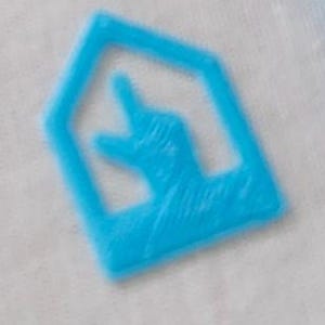 May include: A light blue house-shaped sticker with a hand pointing up inside.