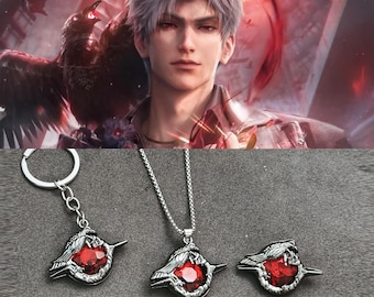 May include: A silver-toned keychain, necklace, and ring set. Each piece features a bird-like design with a large, red gemstone center. The background includes a digital illustration of a person and a bird.