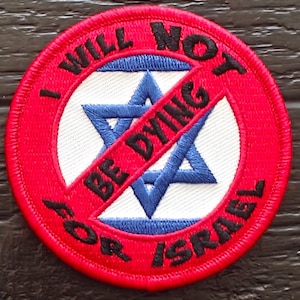 May include: Embroidered patch with a red border and the text "I WILL NOT BE DYING FOR ISRAEL" in black. The patch features a blue Star of David with a red diagonal line through it.