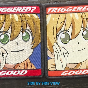 以下が含まれることがあります： 2つの刺繍パッチが並んでおり、それぞれ緑色の目と薄茶色の髪の毛を持つアニメスタイルのキャラクターが描かれています。パッチにはキャラクターの上に「TRIGGERED？」、下に「GOOD」という文字が書かれています。背景は青色です。