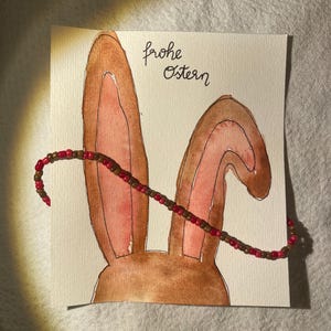 Carta acquerello con scritta a mano e collana di perle abbinata