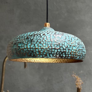 May include: A teal and gold hammered metal pendant light fixture with a round dome shape.
