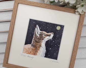 May include: A framed watercolour painting of a fox gazing up at the moon in a starry night sky. The painting is titled "Moon Gazing" and signed "S.Mara".