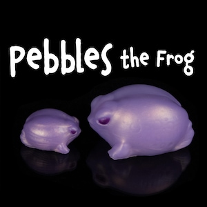 May include: Two purple frog figurines, one larger than the other, with a shiny, pearlescent finish. The larger frog is labeled "Pebbles the Frog".