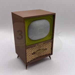 May include: A brown and green vintage-style television set with a woven fabric speaker grille. The television has a round screen and a small handle on the front.