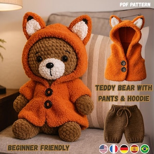 Op de afbeelding: Een gehaakte teddybeer met een oranje vossenhoodie en bijpassende broek. De beer heeft een witte snuit en zwarte knoopogen. De afbeelding toont ook een vest en de tekst "TEDDY BEAR WITH PANTS & HOODIE" en "BEGINNER FRIENDLY".